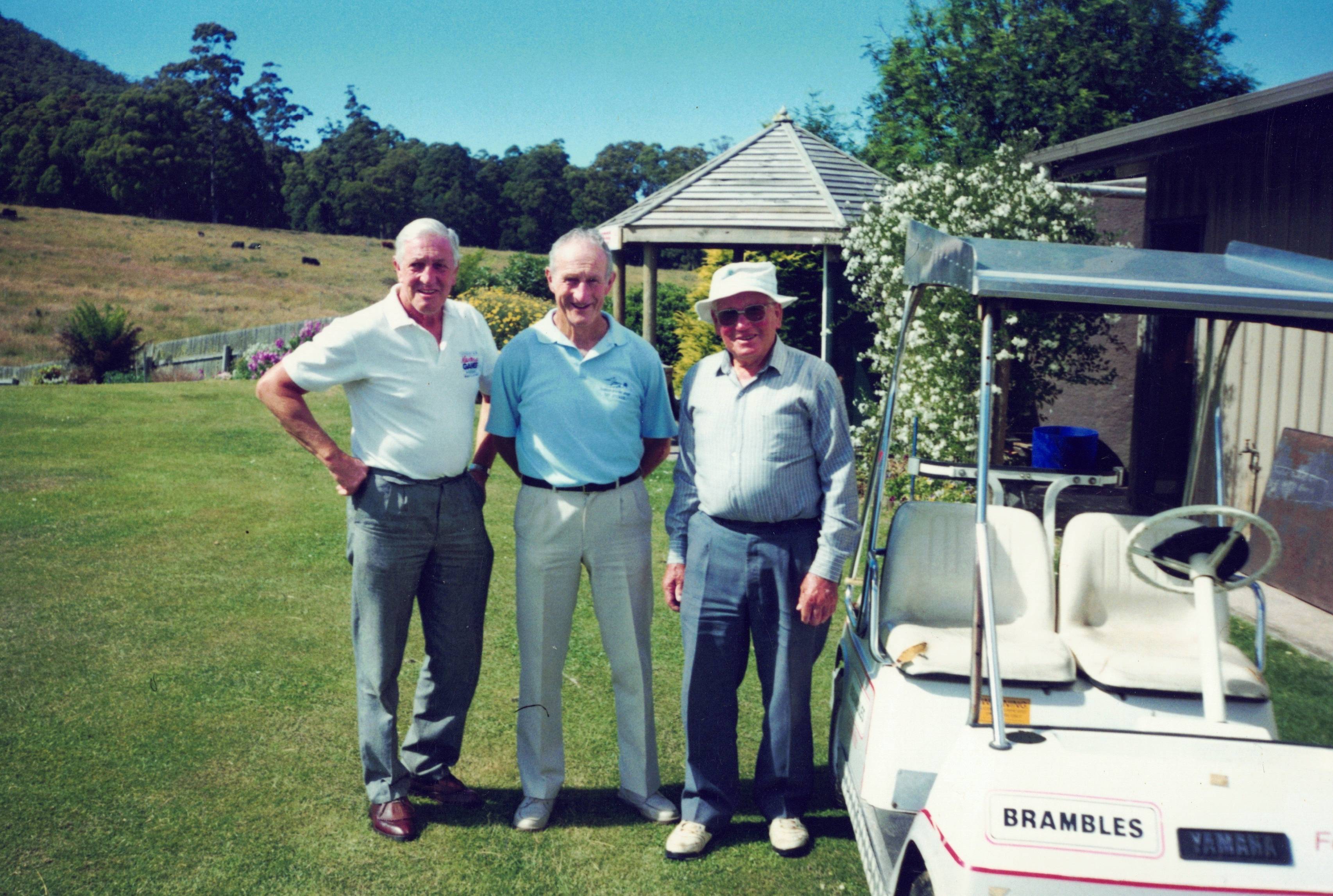 Three Players by Cart at Clubhouse Three Players by Cart at Clubhouse