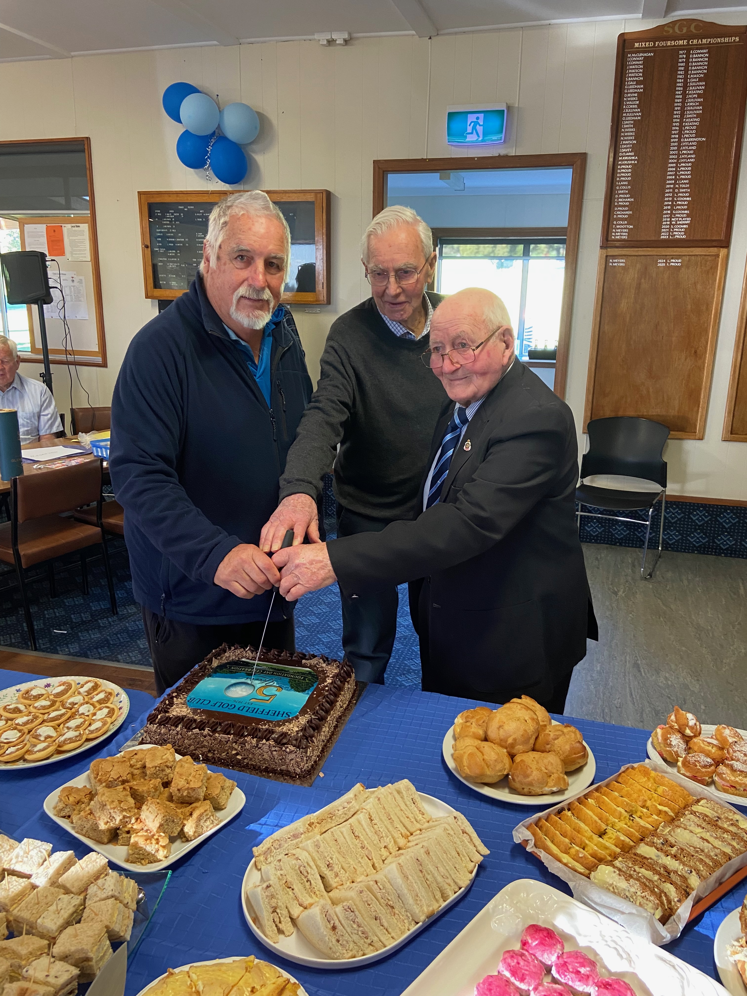 Neil, John and Ian cut the celebratory cake.